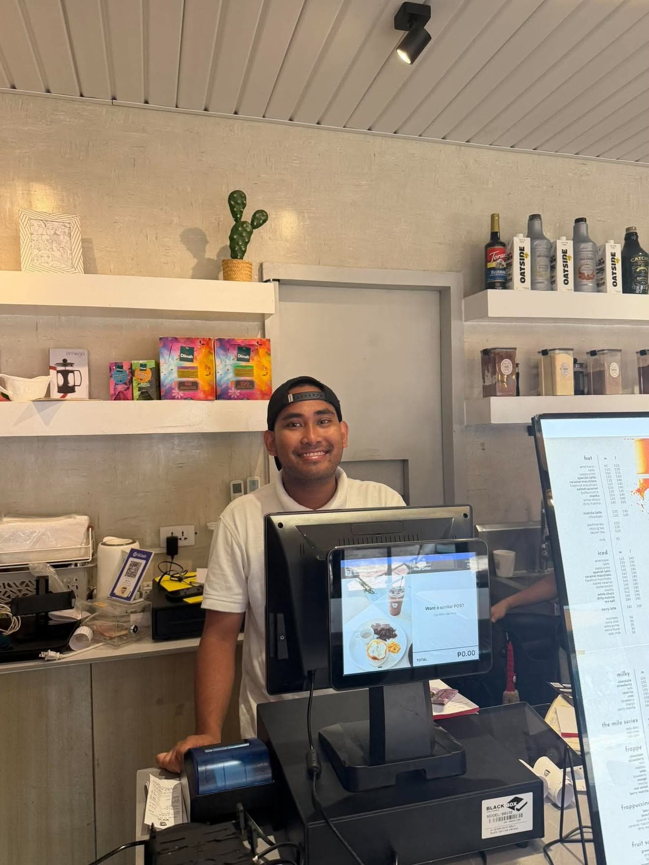 A barista at the Dwntwn Cafe counter with the UltraPOS terminal and customer display